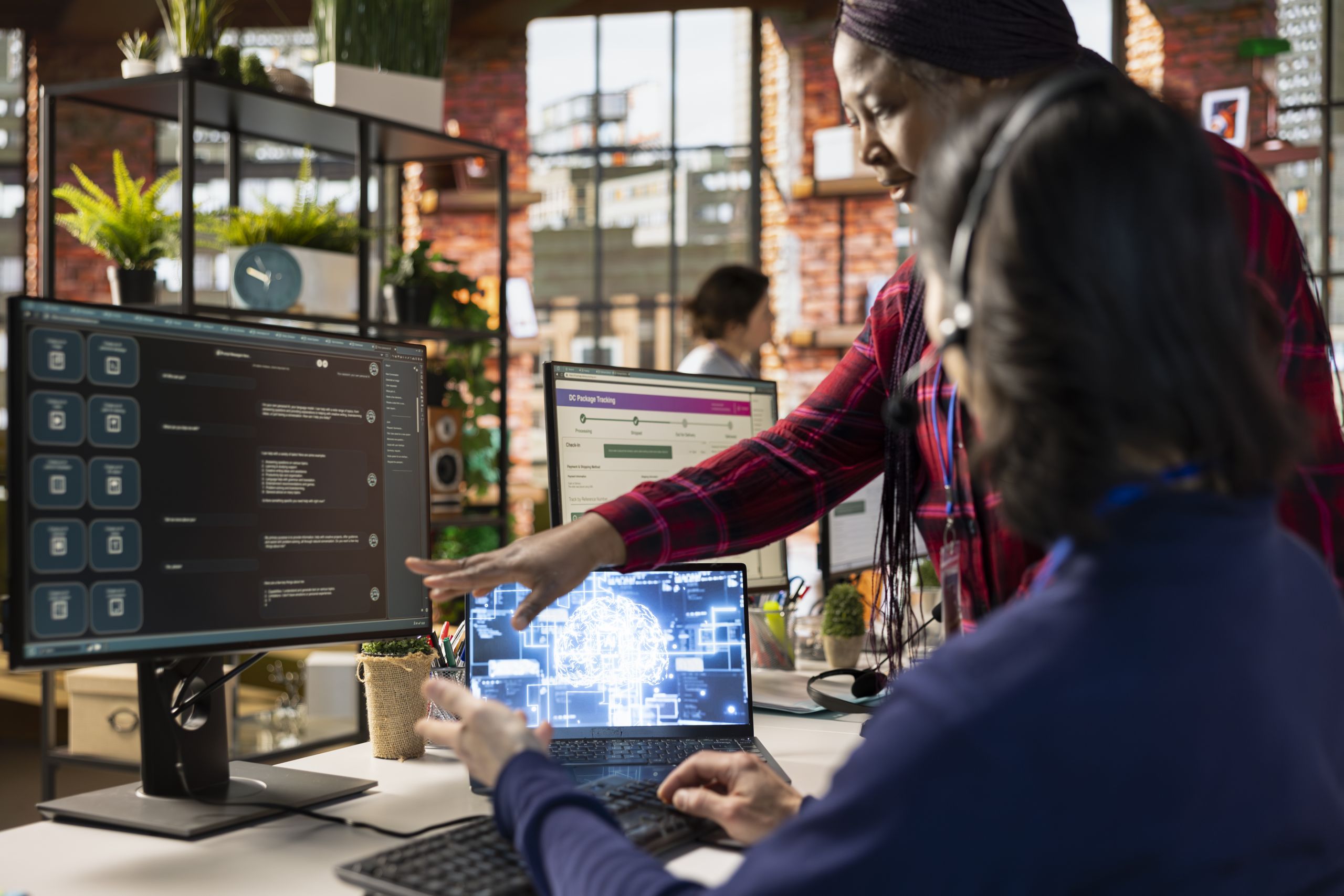 Call center onboarding specialist training new agent on helpful artificial intelligence tools. African american manager in customer support department office shows man how to use company AI software